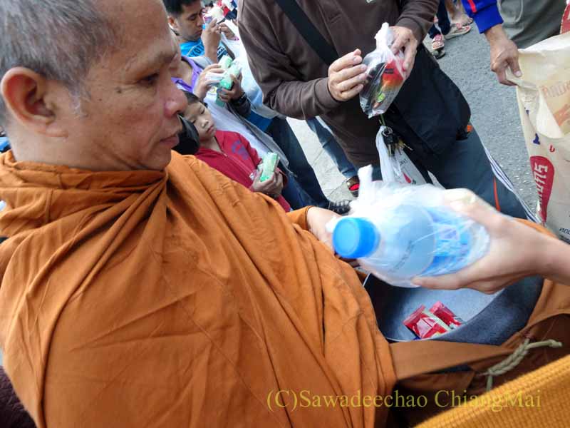チェンマイの元旦の特別タムブンで托鉢をする僧侶