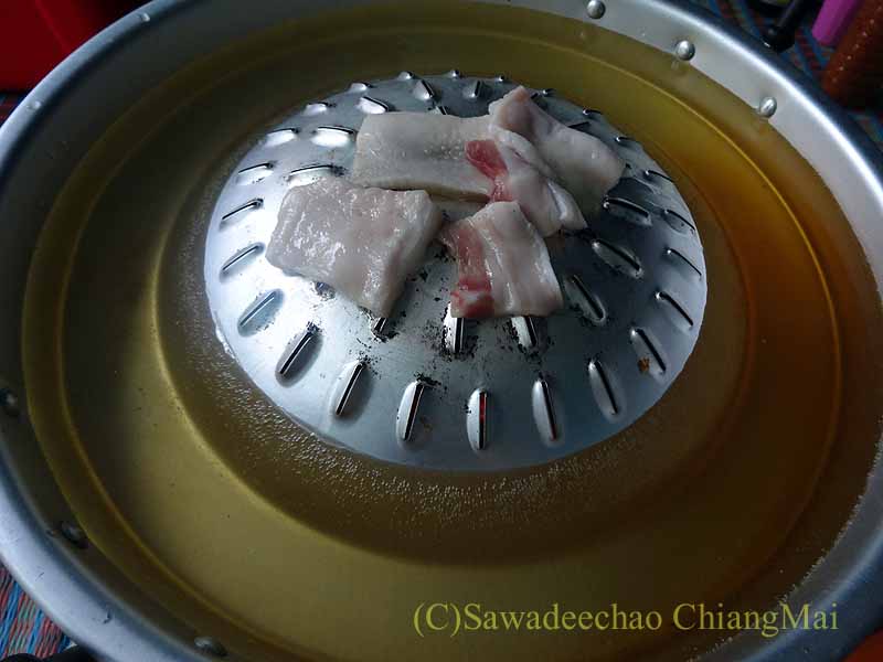 チェンマイのタイ人の家でのムーガタの鍋に乗せた豚脂身