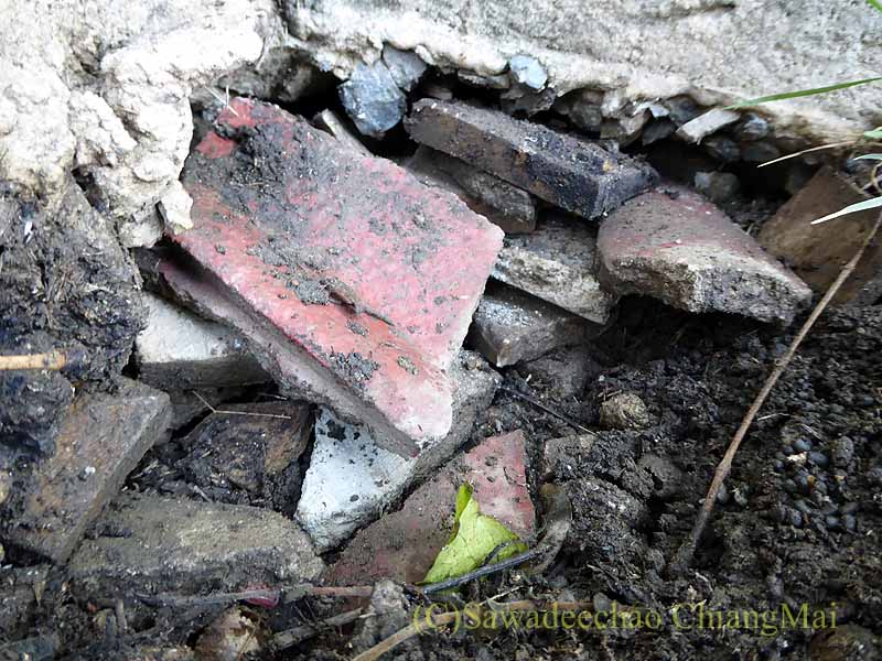 チェンマイの自宅の庭に開いた蛇の穴に瓦礫を埋める