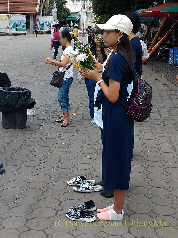 チェンマイのワットプラタートシーチョームトーンの仏塔前で祈る人々