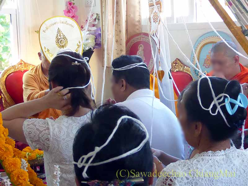 チェンマイの新築祝いで参加者の頭に巻かれた聖糸
