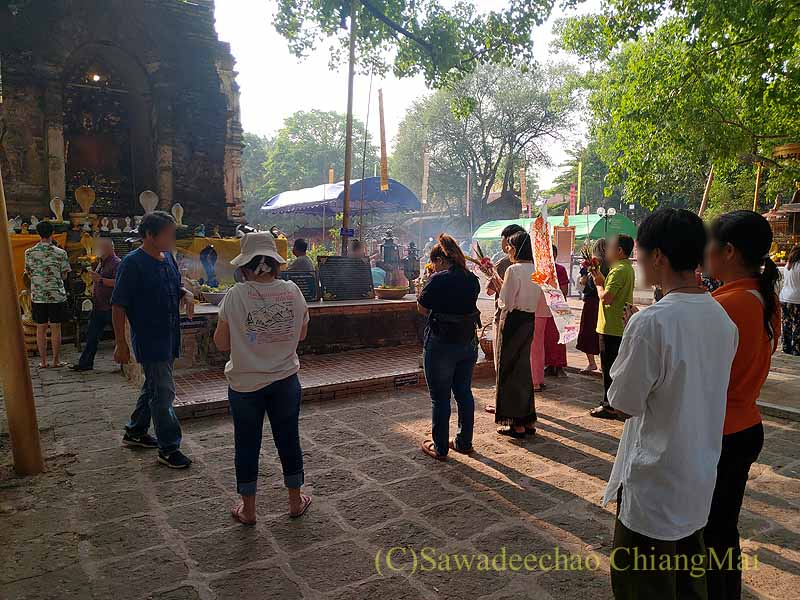 チェンマイの寺院ワットチェットヨートの仏塔で祈る人